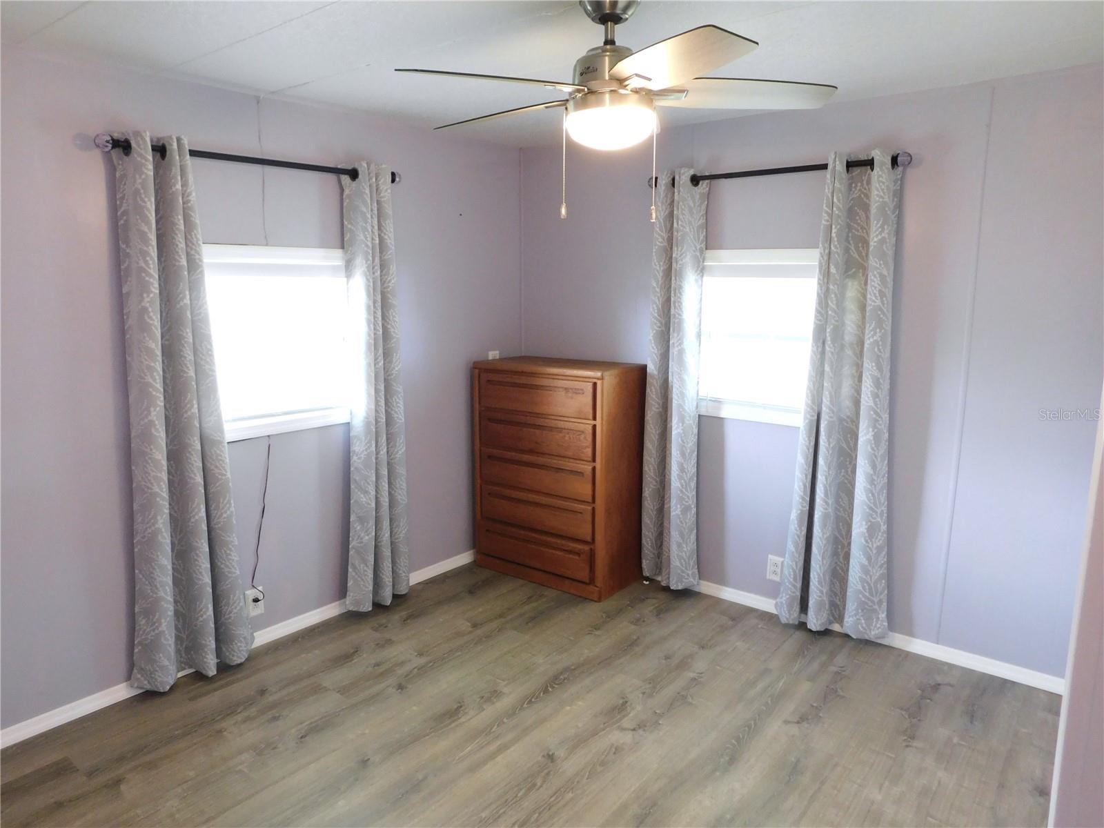 Main bedroom has ceiling fan, new flooring, fresh paint, and flooring.