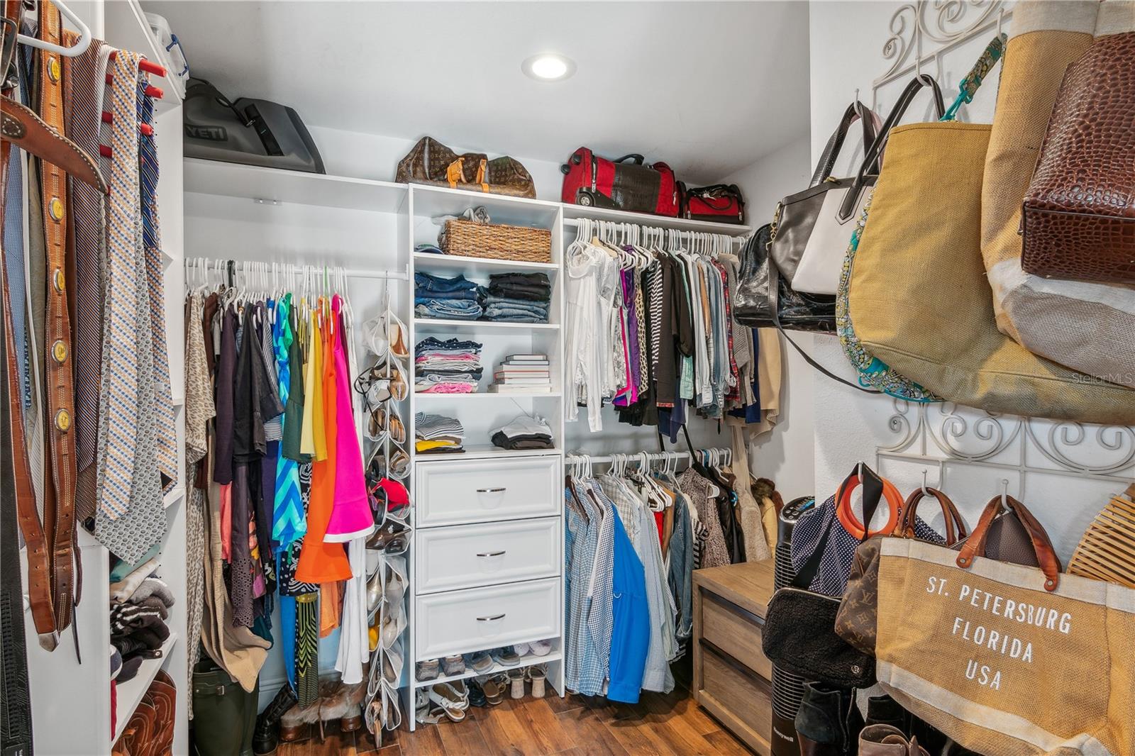 Ample primary closet with shelves and drawers...