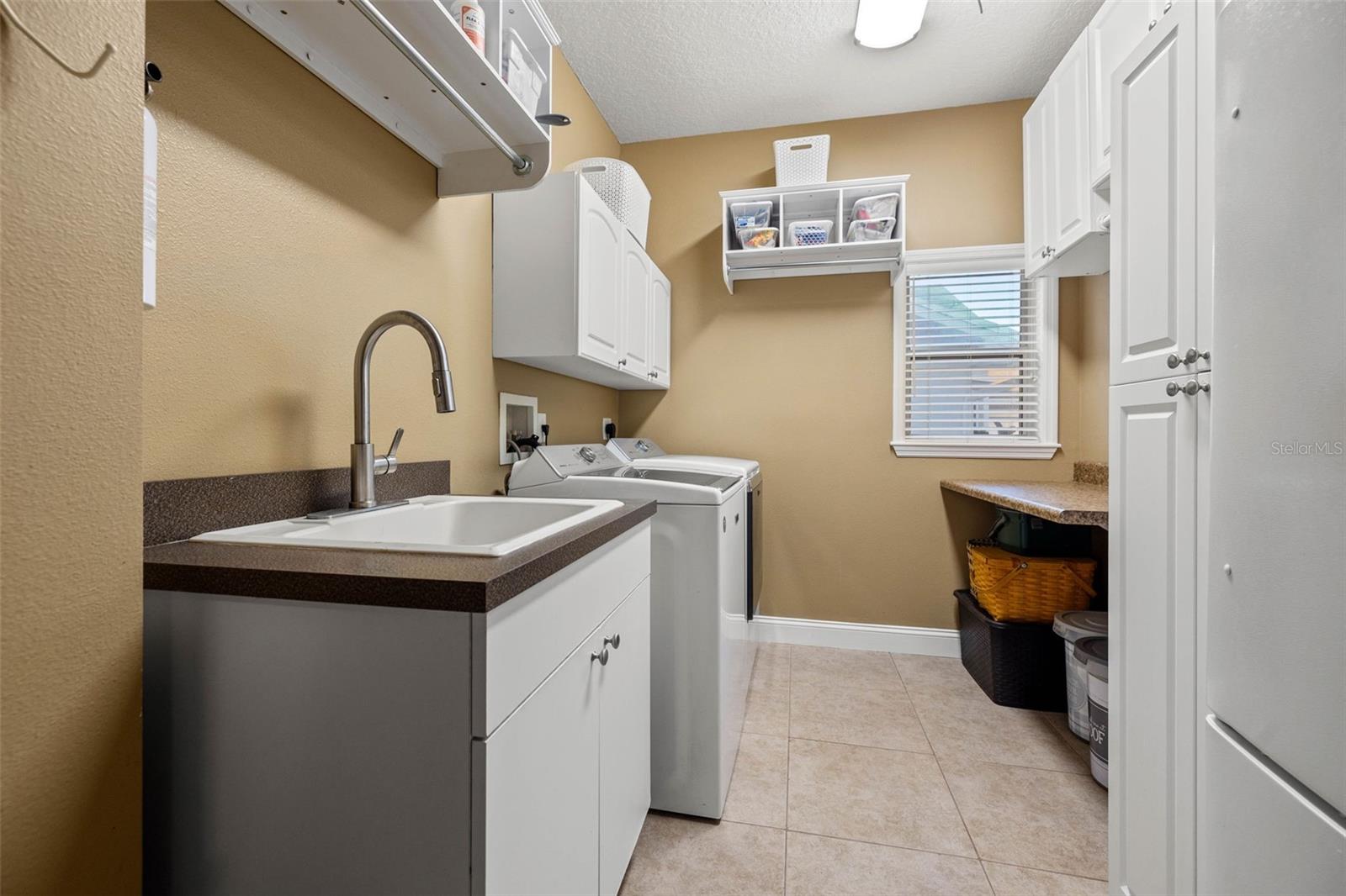 Indoor laundry & utility room with second fridge