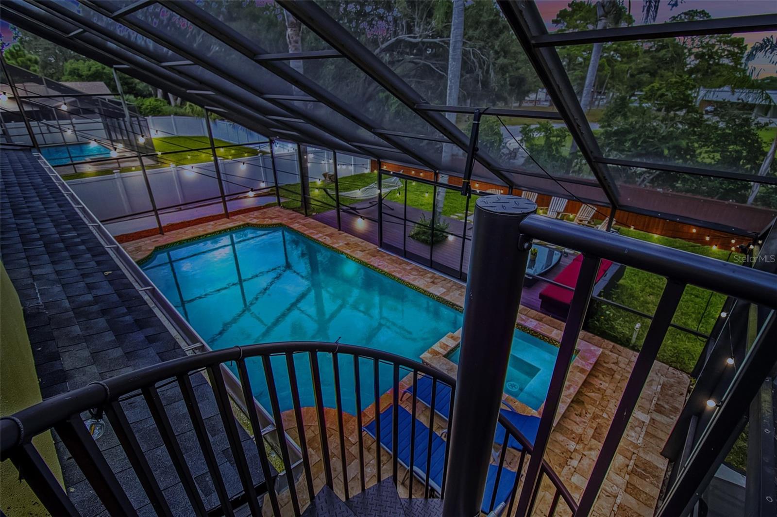 Spiral staircase leading down from private balcony to pool area