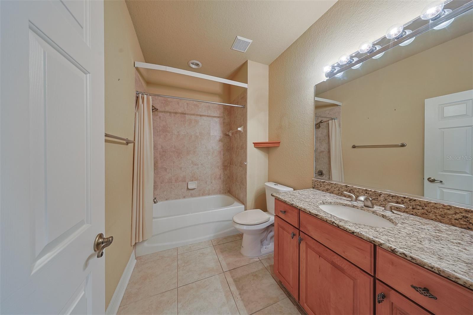 Guest Bathroom with shower and tub is sparkling clean, neat and handsome.  Again, with matching cabinets and granite countertops.