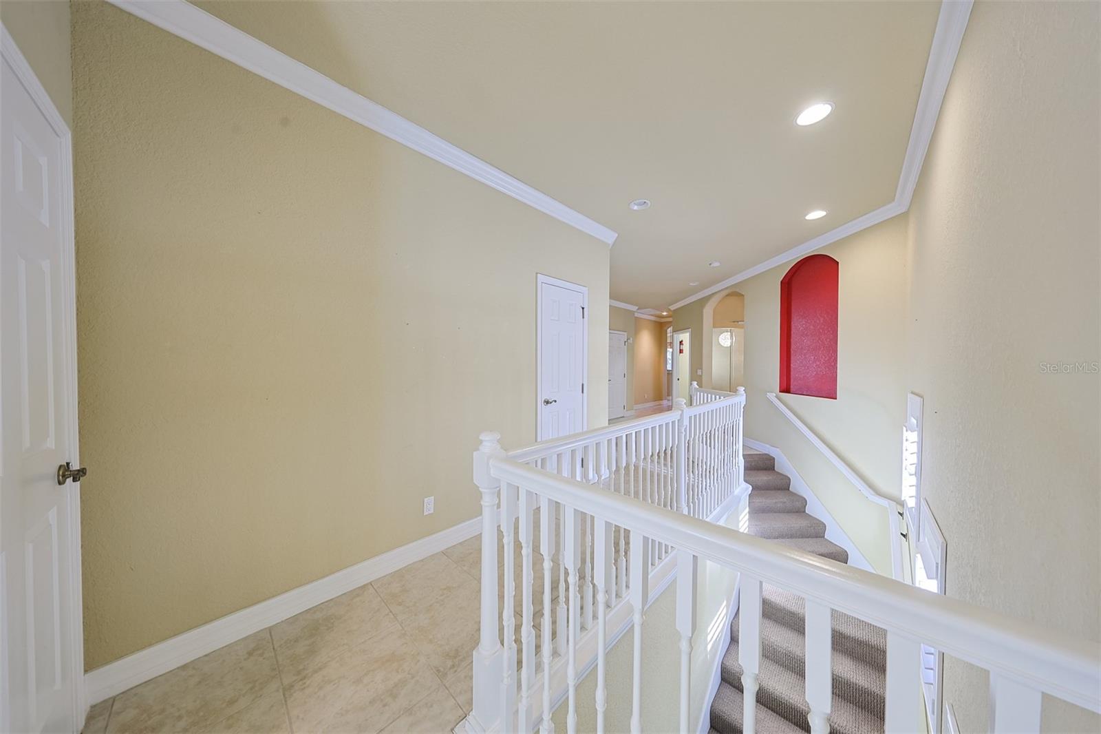 A view from the elevator, lined with a classy white stair railing.  Both the stairs and the private elevator leads to the front door and downstairs garage.