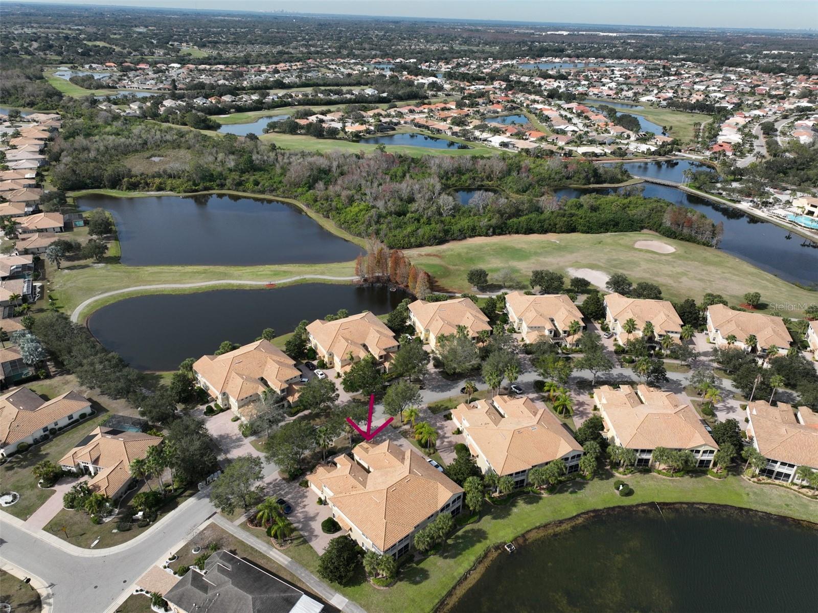 Aerial water and golf course view of condo.