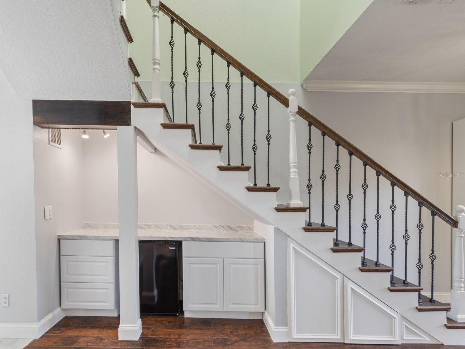 Reconfigured staircase with built-ins and mini fridge underneath