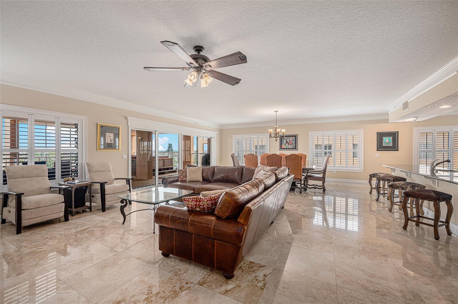 Combination great room is surrounded by an abundance of windows, sliding doors, and the beauty of Florida's sunshine!  Plantation Shutters on windows throughout the home.