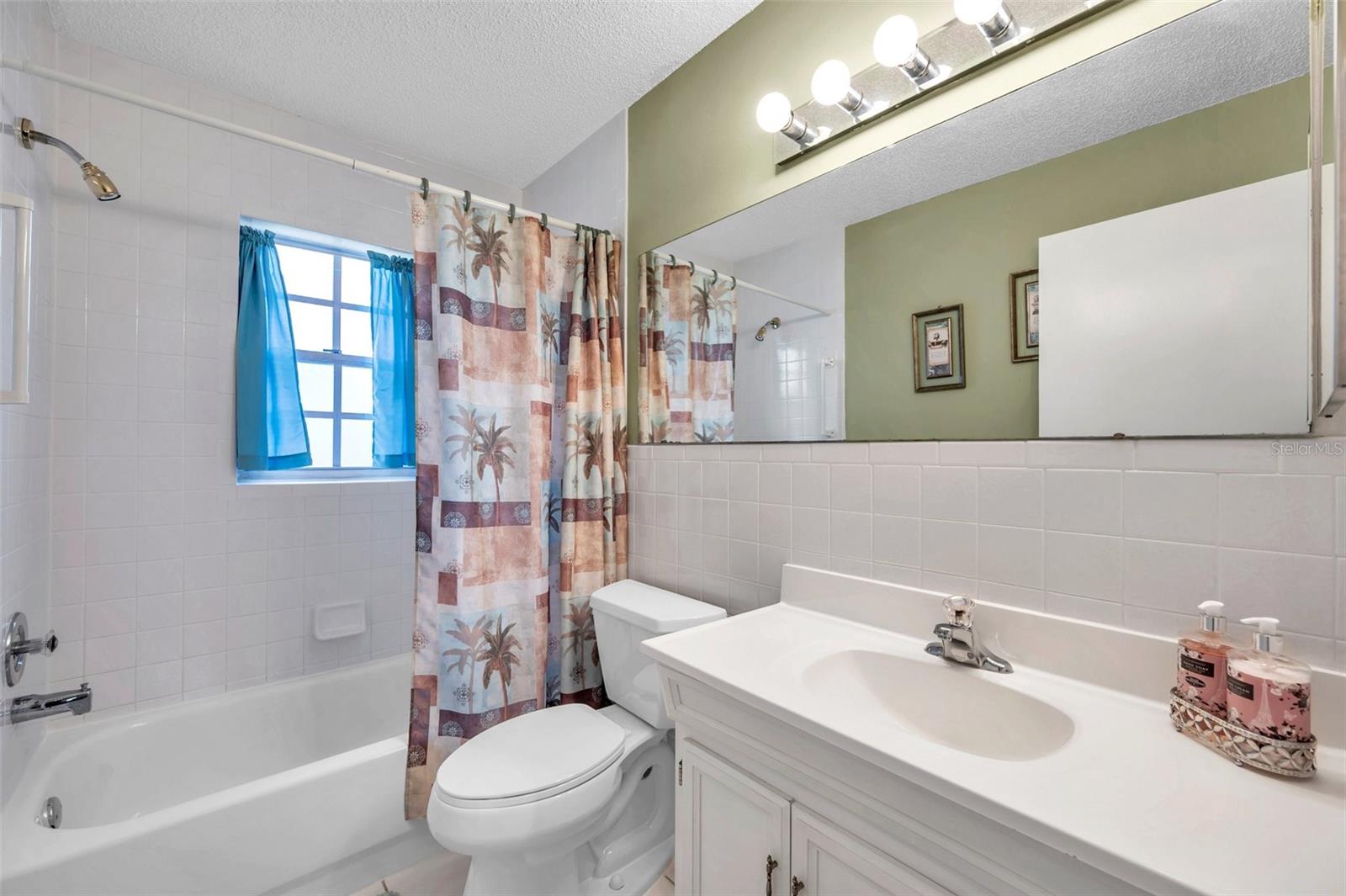 Guest bathroom has tub with shower, newer commode, newer vanity, ceramic tile floor and a nice window!