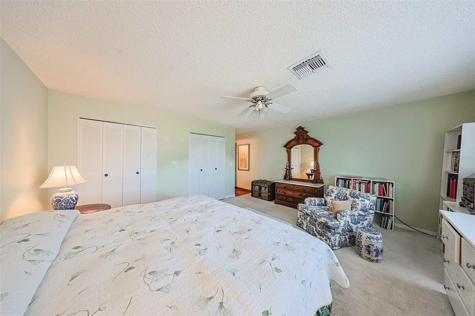 This room is HUGE, bright and  has relaxing paint tones with a view of the green belt.