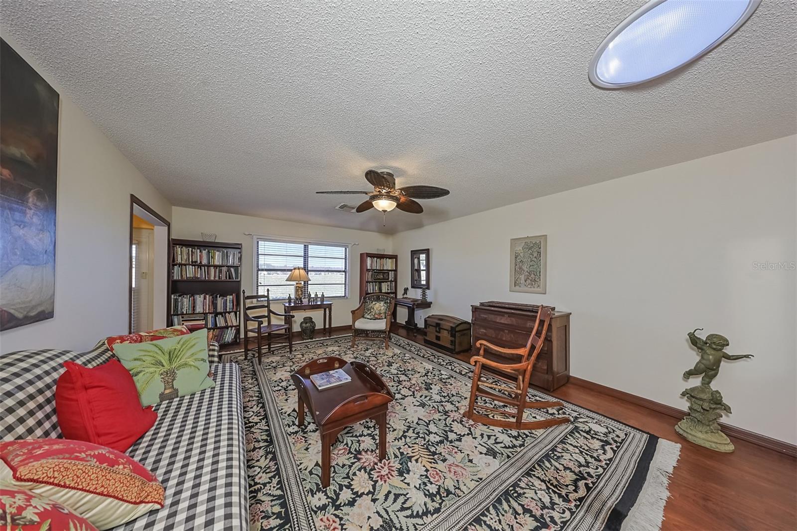 Living Room has neutral colors with a custom ceiling fan including lights.  All furniture and furnishings are remaining with the home, but the seller will remove upon request of the buyer.