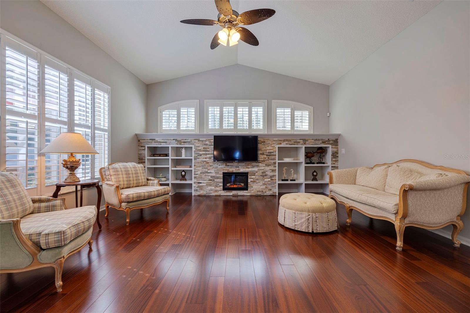 Living Area - Engineered Hardwood Flooring, Plantation Shutters, Stacked Stone Accent Wall, Ample Natural Lighting