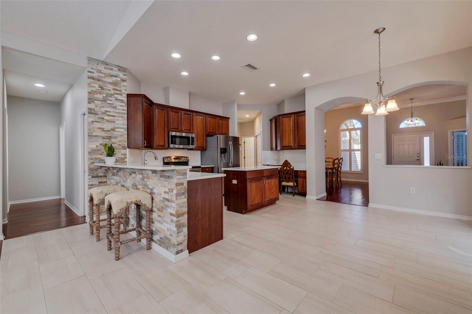 Kitchen - Stacked Stone Accent Wall, Breakfast Bar Seating, Quartz Countertops, Solid Wood Cabinetry, Stainless Steel Appliances, Center Island