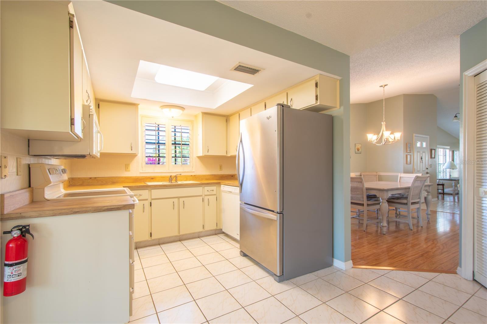 The kitchen features ceramic tile floor and plantation shutters.