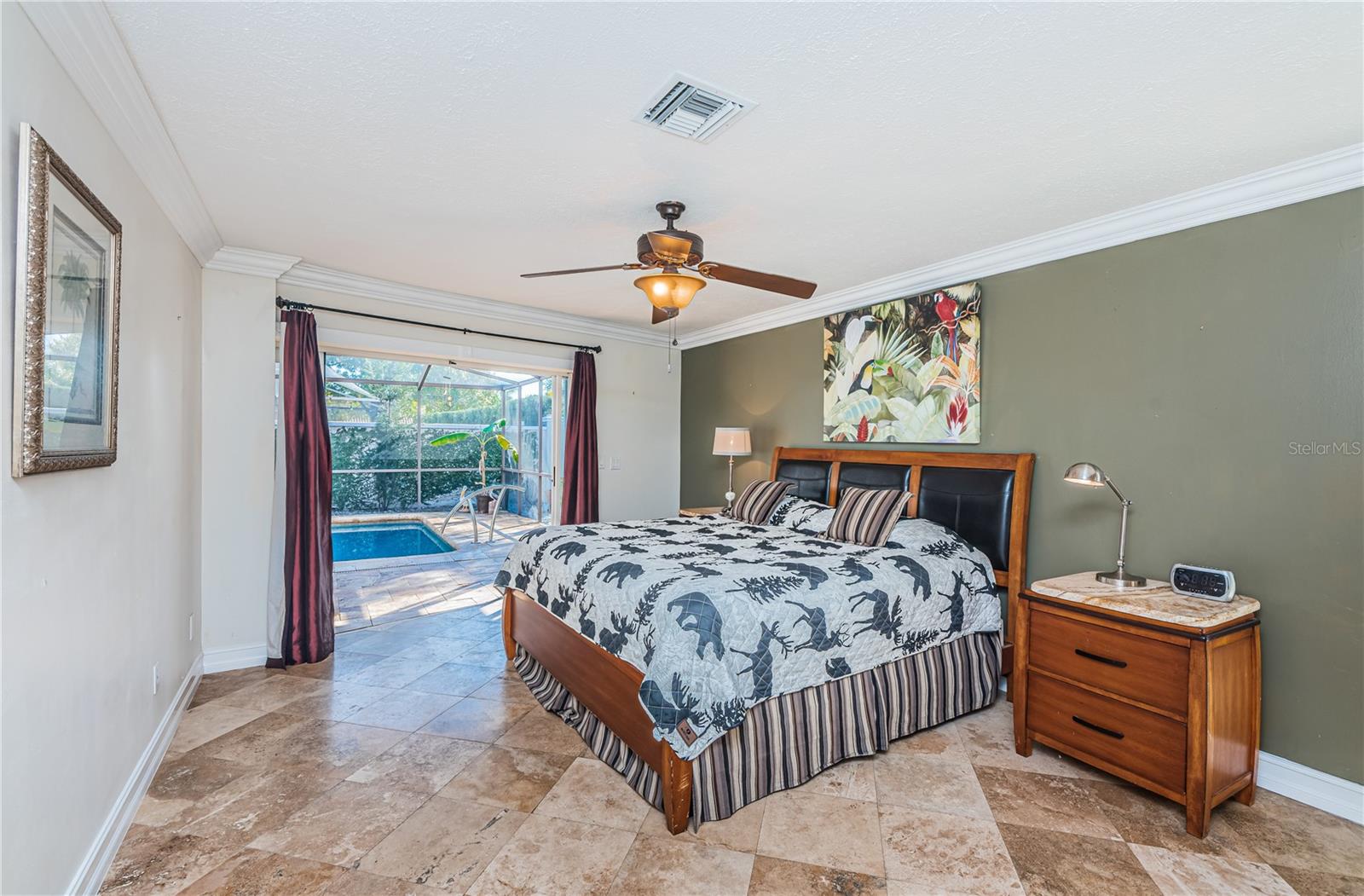 Master bedroom overlooks pool and features travertine flooring.