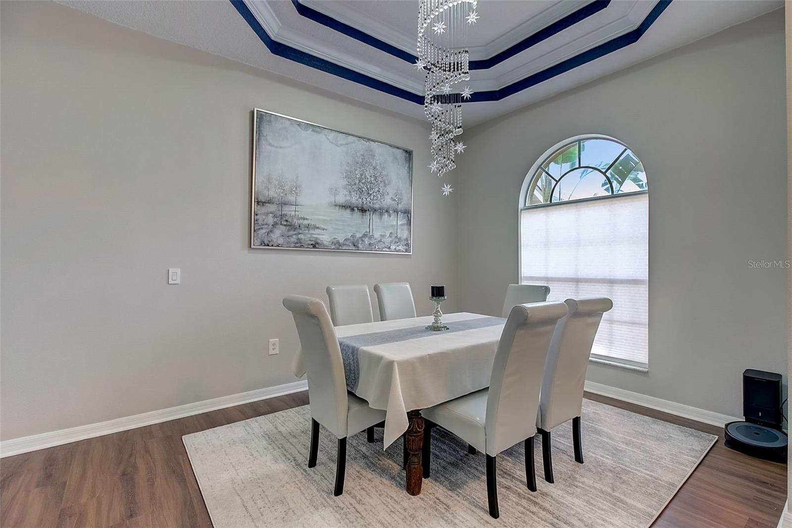 Formal Dining area with gorgeous light fixture and multi- level tray ceiling and crown molding