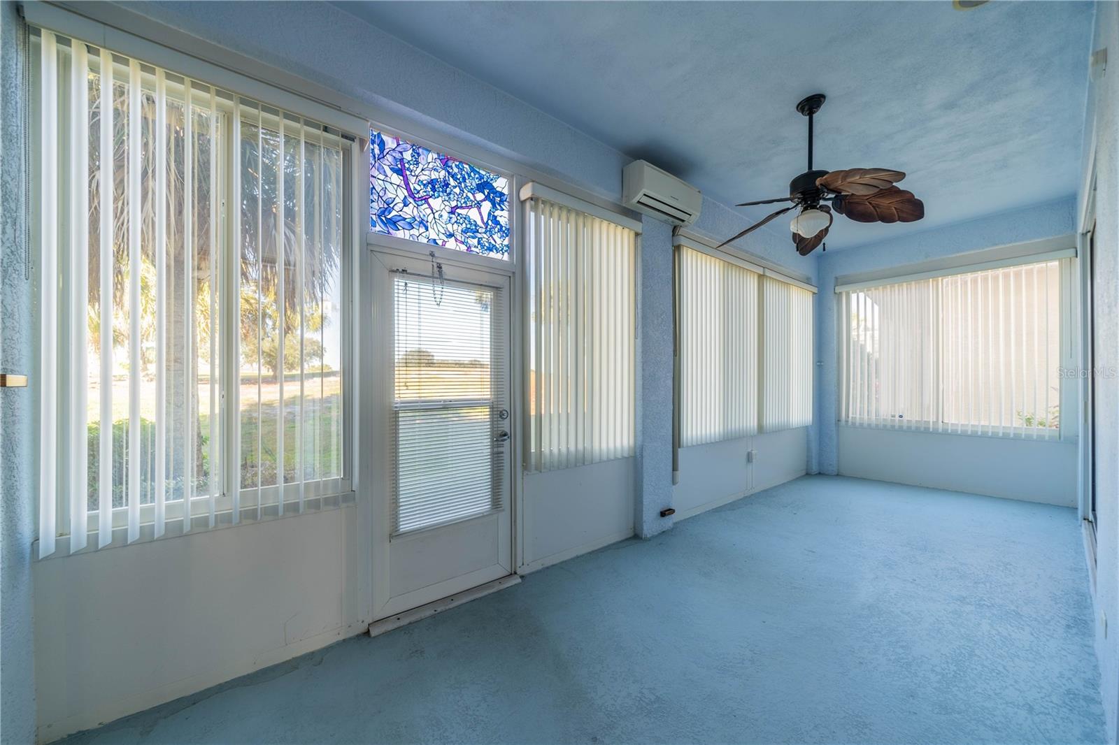Lanai under air with door leading out to golf course