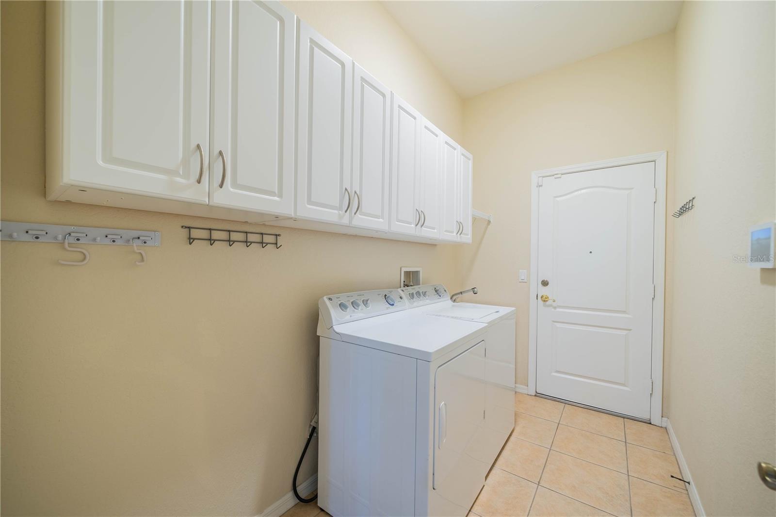Laundry room with washer/dryer, sink, cabinets and extra space on left