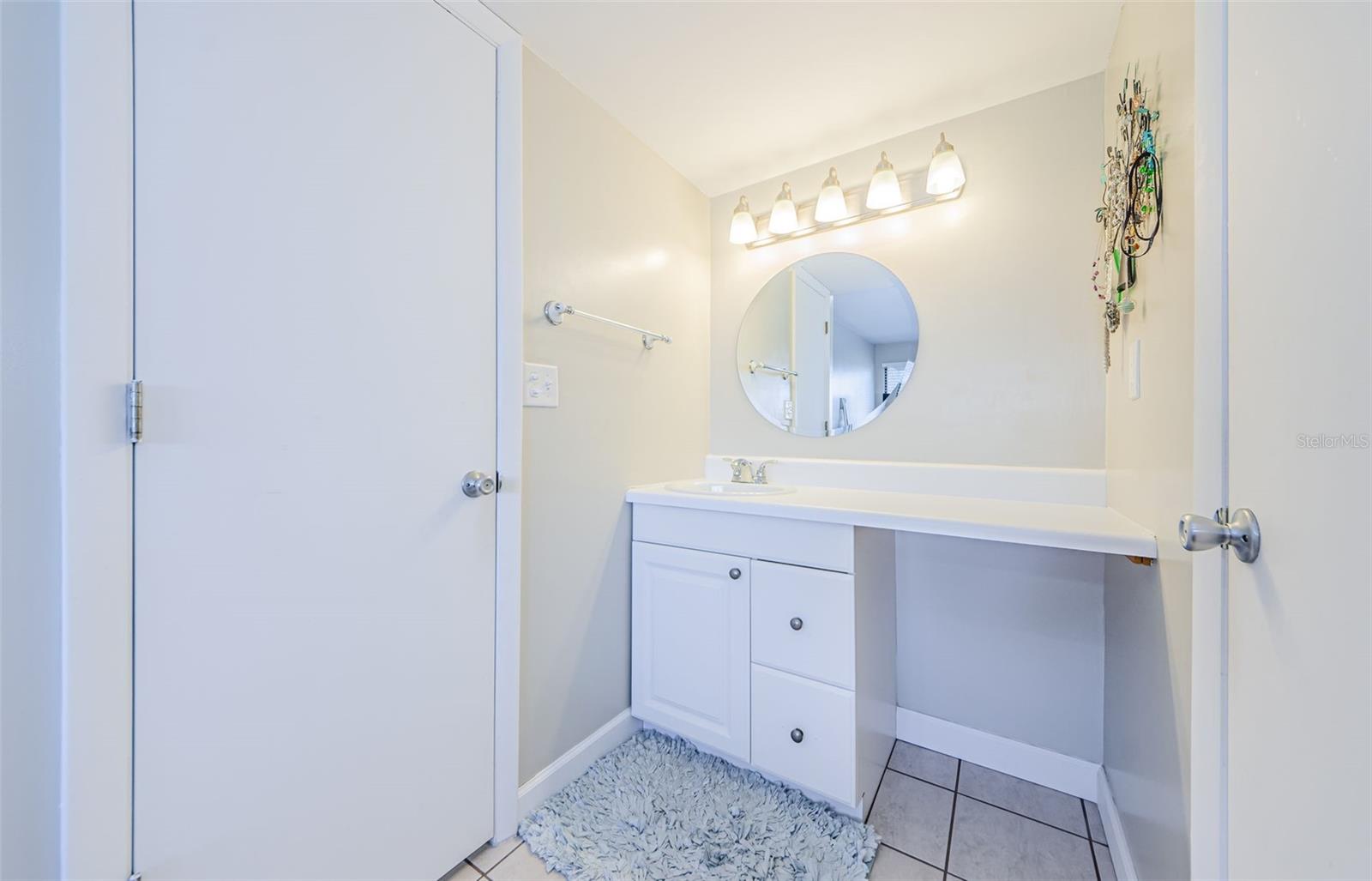 Vanity area, walk in closet on the right, entrance to tub/shower combination