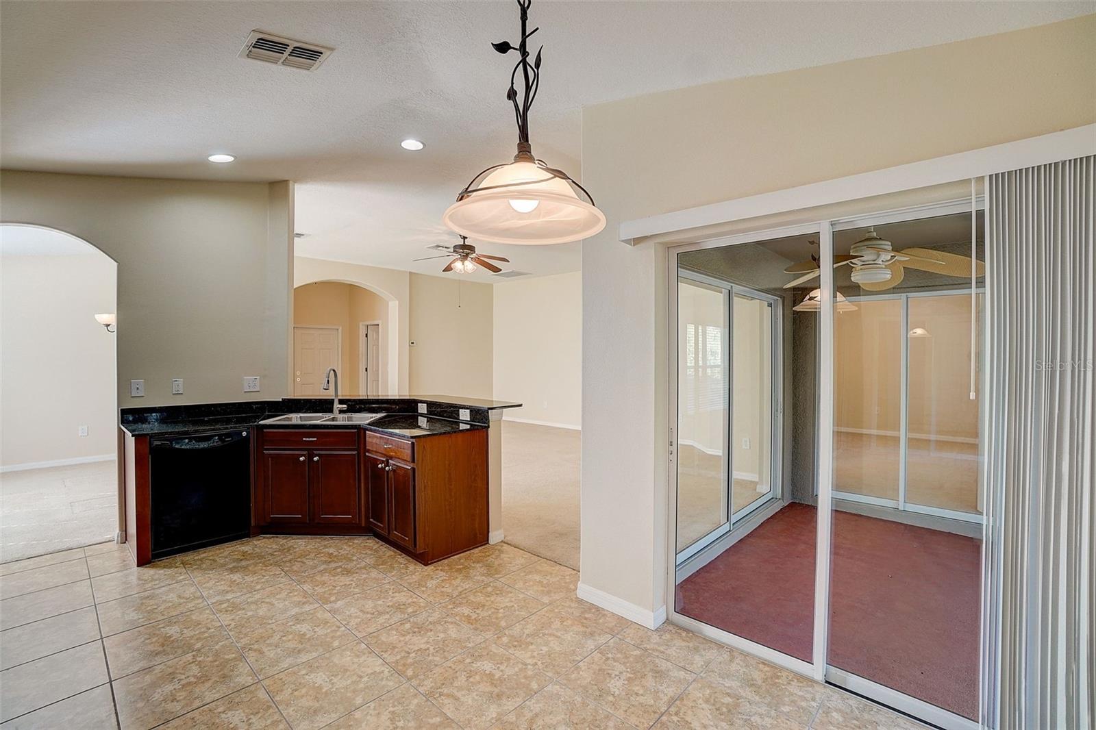 Kitchen leads right to covered lanai through sliders.