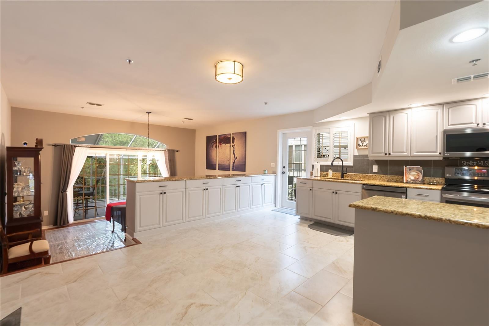 The large buffet cabinets and granite counter top separate the kitchen from the dining room.
