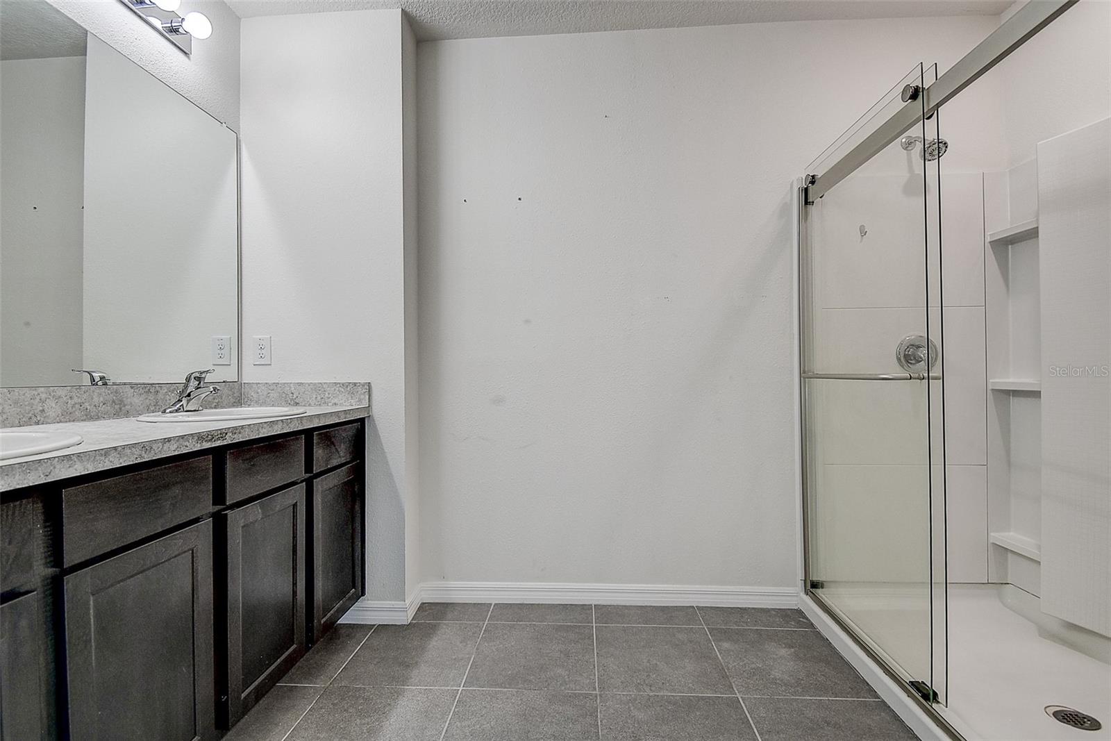 Primary bathroom with dual sinks, upgraded glass doors on walk-in shower.