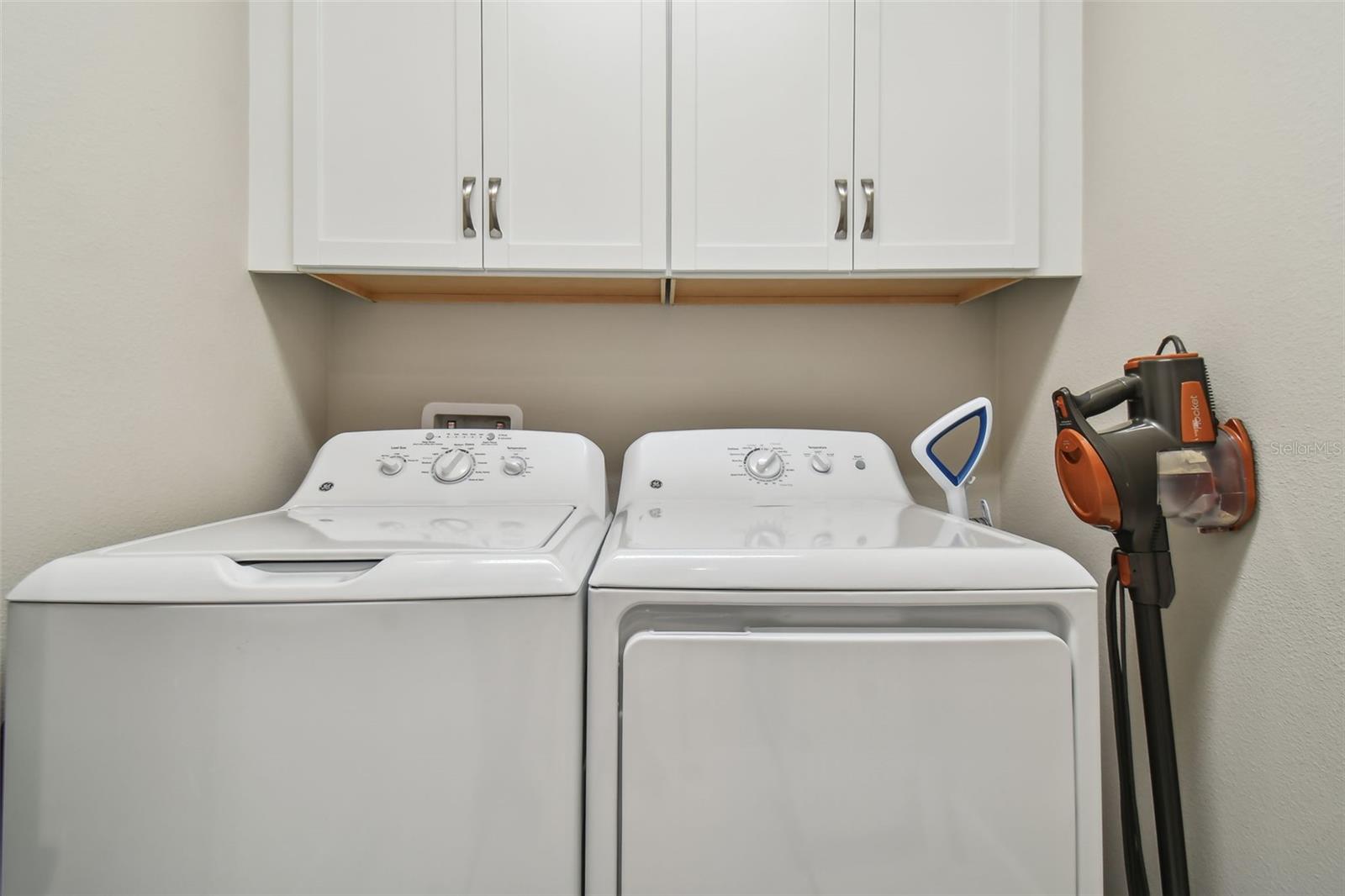 Laundry room with extra storage cabinets and gas dryer.