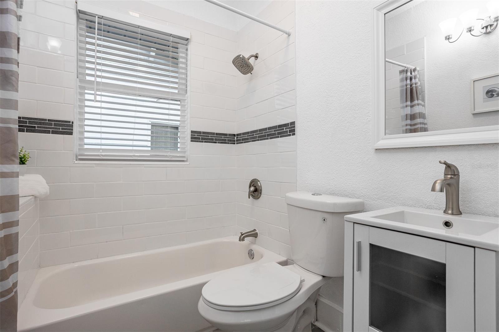 Third bathroom with tub and shower combo between third and fourth bedrooms