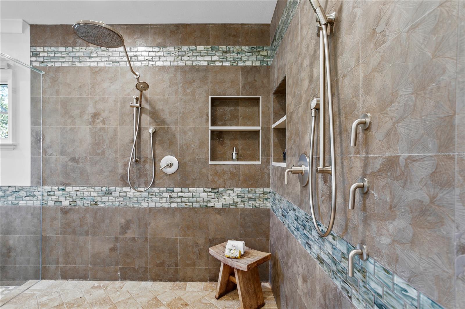 The updated primary bathroom has a large shower with 2 shower heads and 2 sprayers.