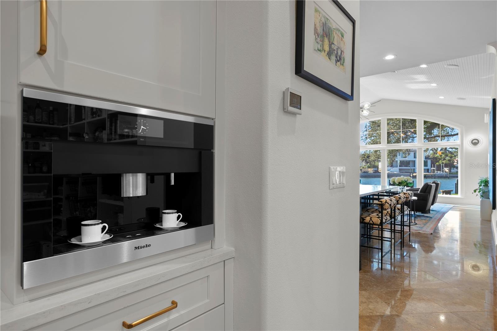 The butler pantry has a dry bar, Miele coffee maker and access to the oversized walk-in updated pantry.