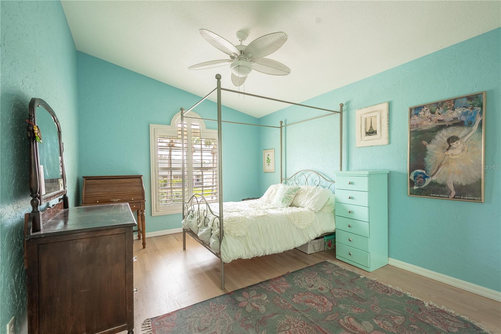Bedroom 3 features high ceilings with ceiling fan, a built in closet, wood floor and plantation shutters.
