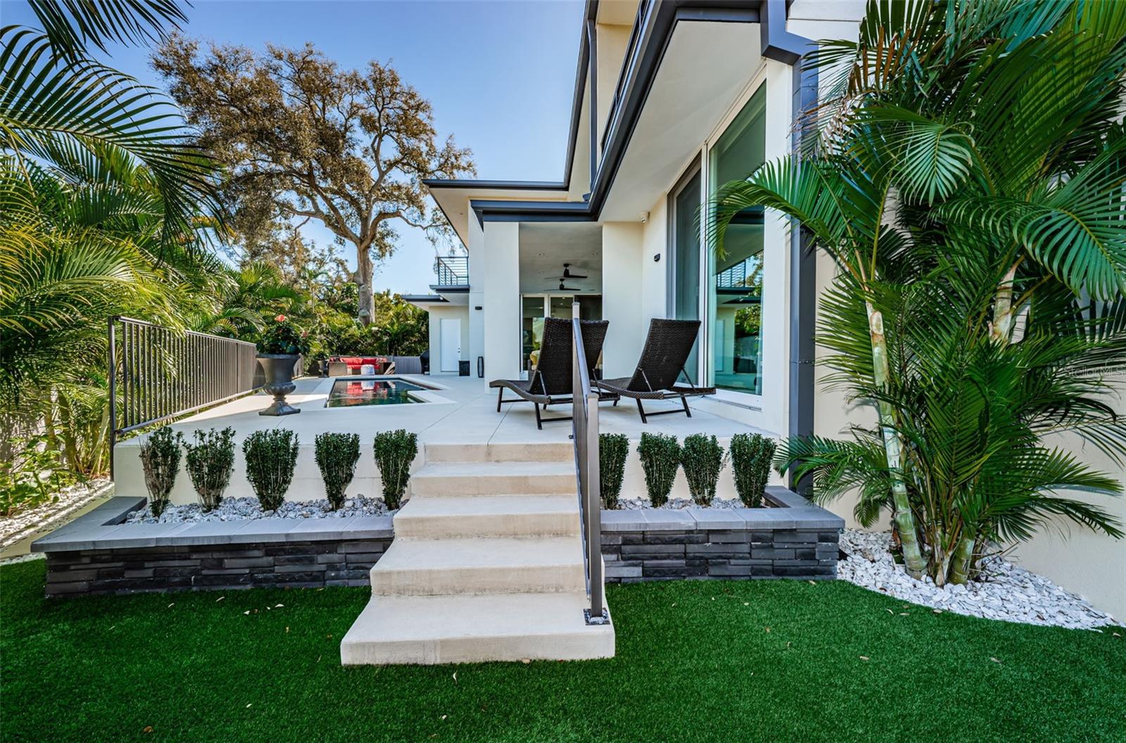 Backyard oasis has been created with lush landscaping, up-lighting, artificial turf on one side and completely private.