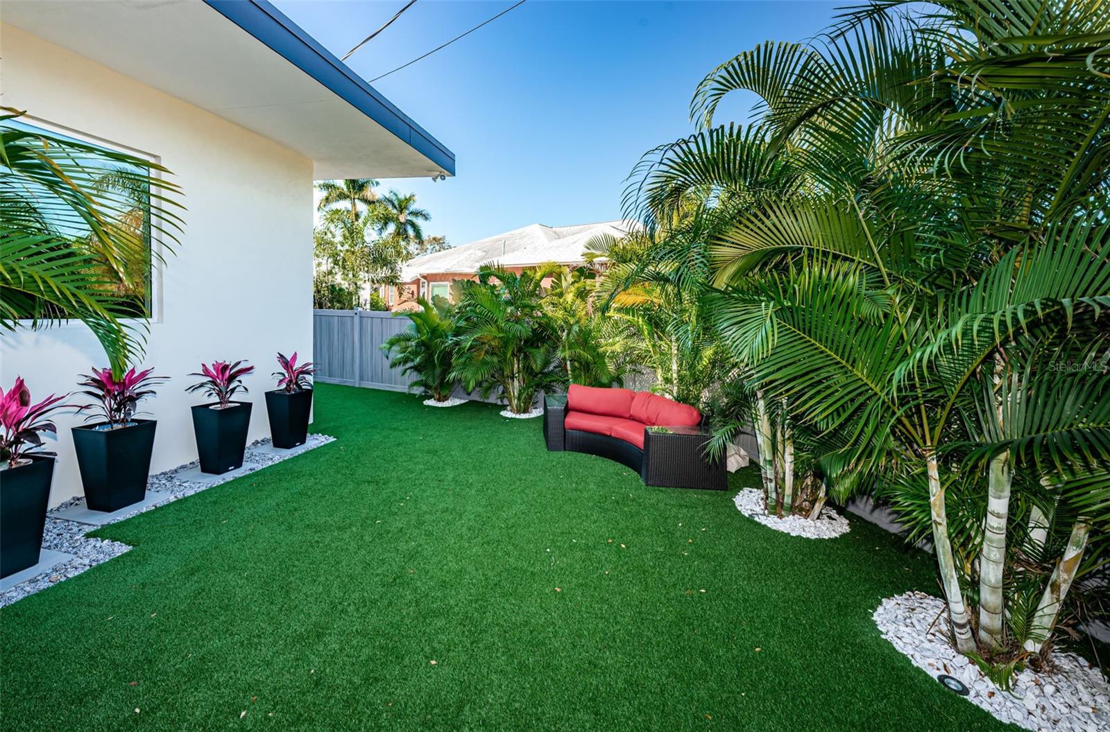 Awesome artificial turf covers part of this gorgeous backyard complete with lots of lush landscaping.