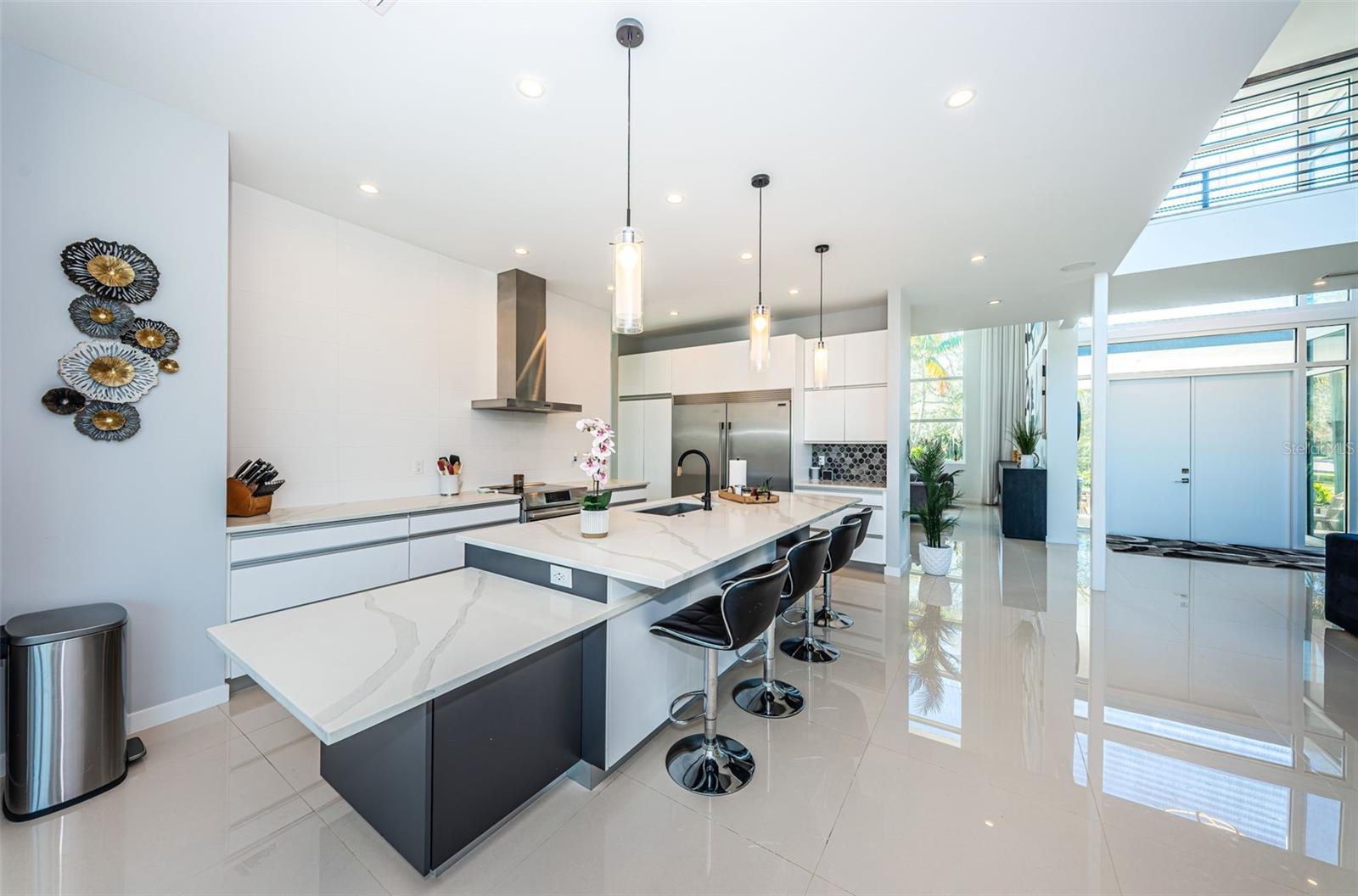 Amazing and open Kitchen with stainless steel appliances, oversize built-in refrigerator/freezer, stunning quartz counters and plentiful cabinets with abundant storage