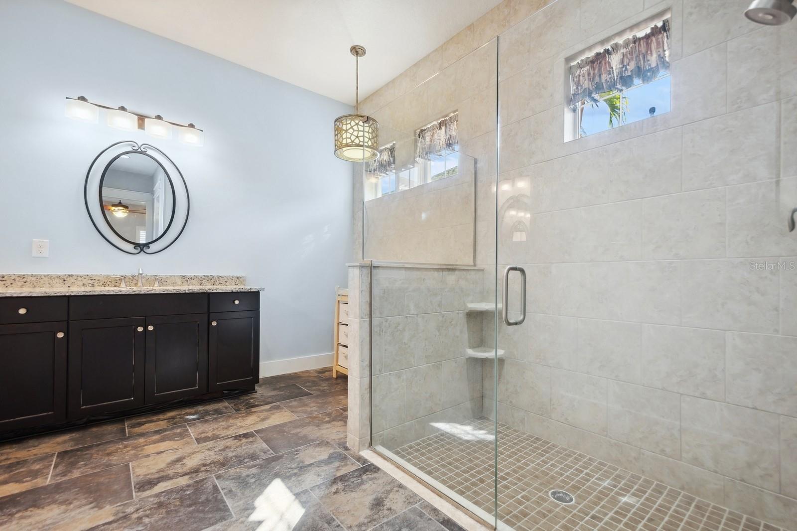 En-suite Bath with large walk in shower, plenty of cabinets for storage, and double sinks.