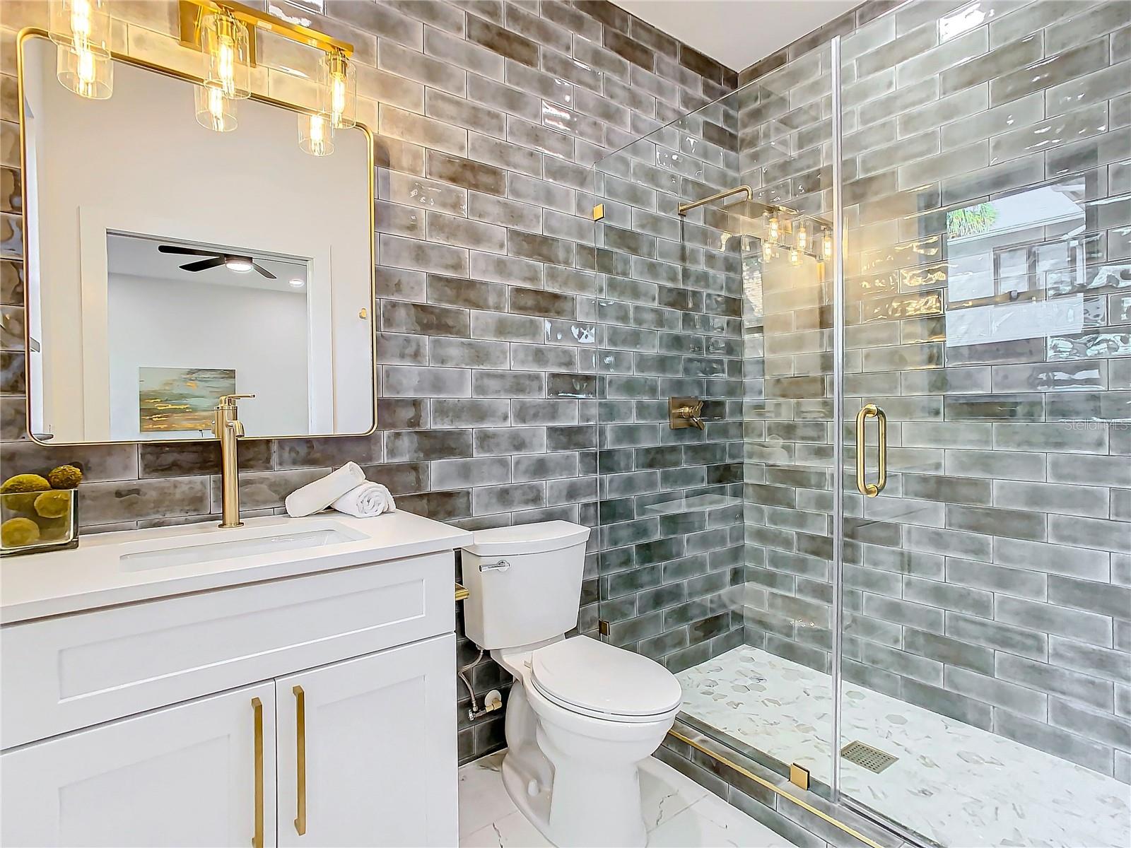 Downstairs Ensuite Bath with Floor to Ceiling Accent Wall and Luxury Hardware