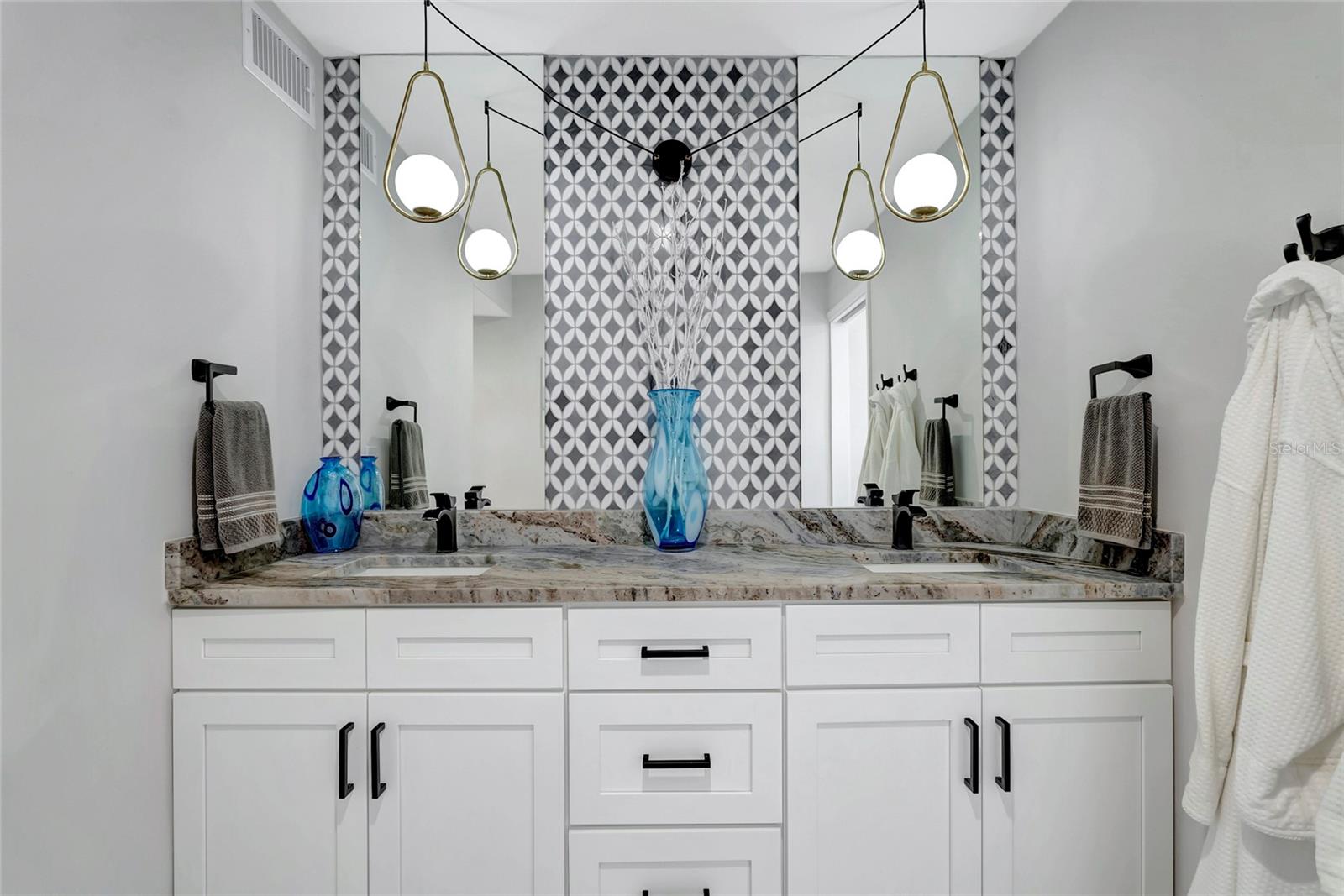 Double vanity with granite countertop and marble backsplash