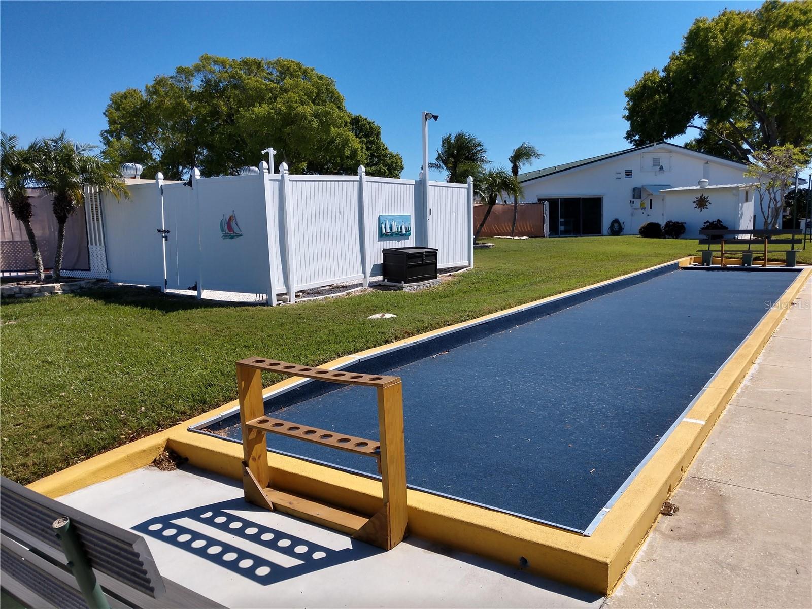 View of community laundry room on back side of clubhouse.  Pool area to left and new bocce court is shown.