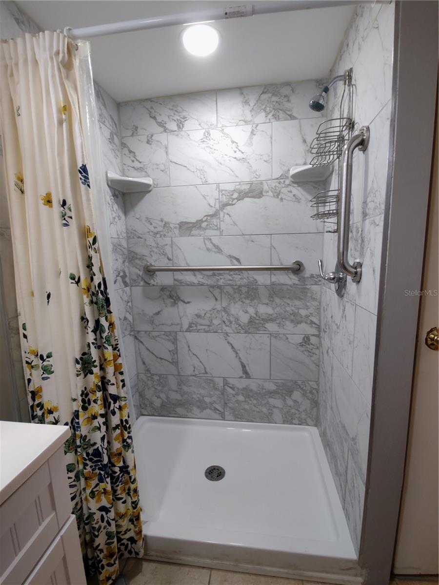 Renovated main bath includes a stunning walk in shower.