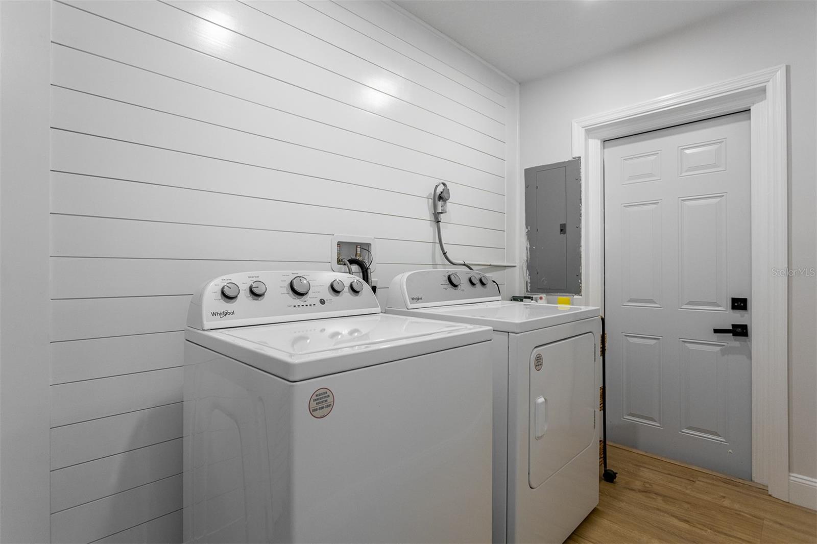 Full sized laundry suite with shiplap walls