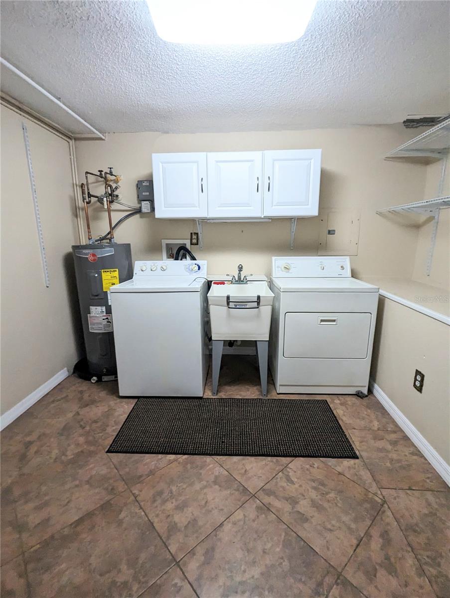 Inside Laundry Room with washer/dryer and wash tub on first level coming in from the garage