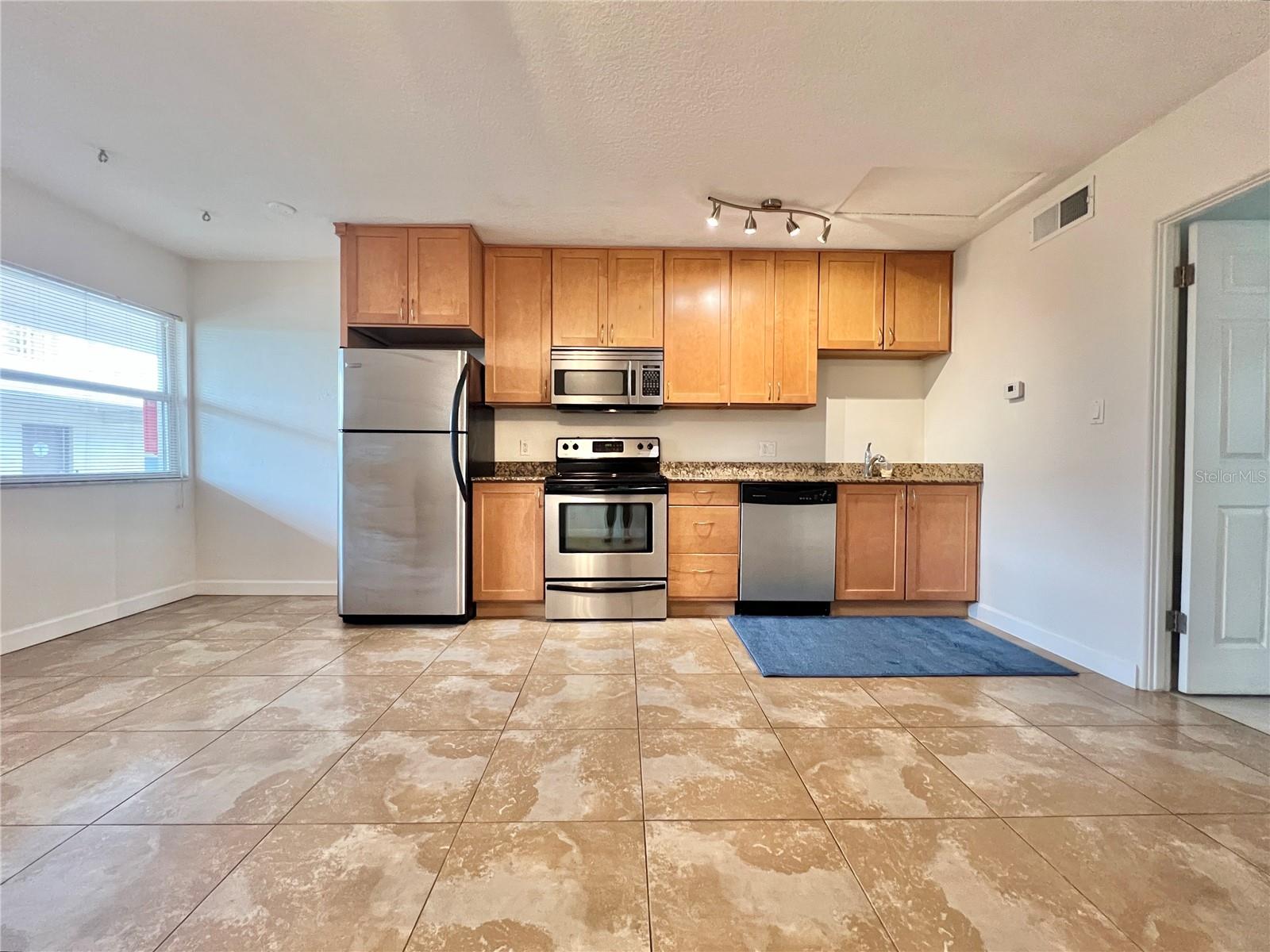 The kitchen features granite countertops and stainless steel appliances.