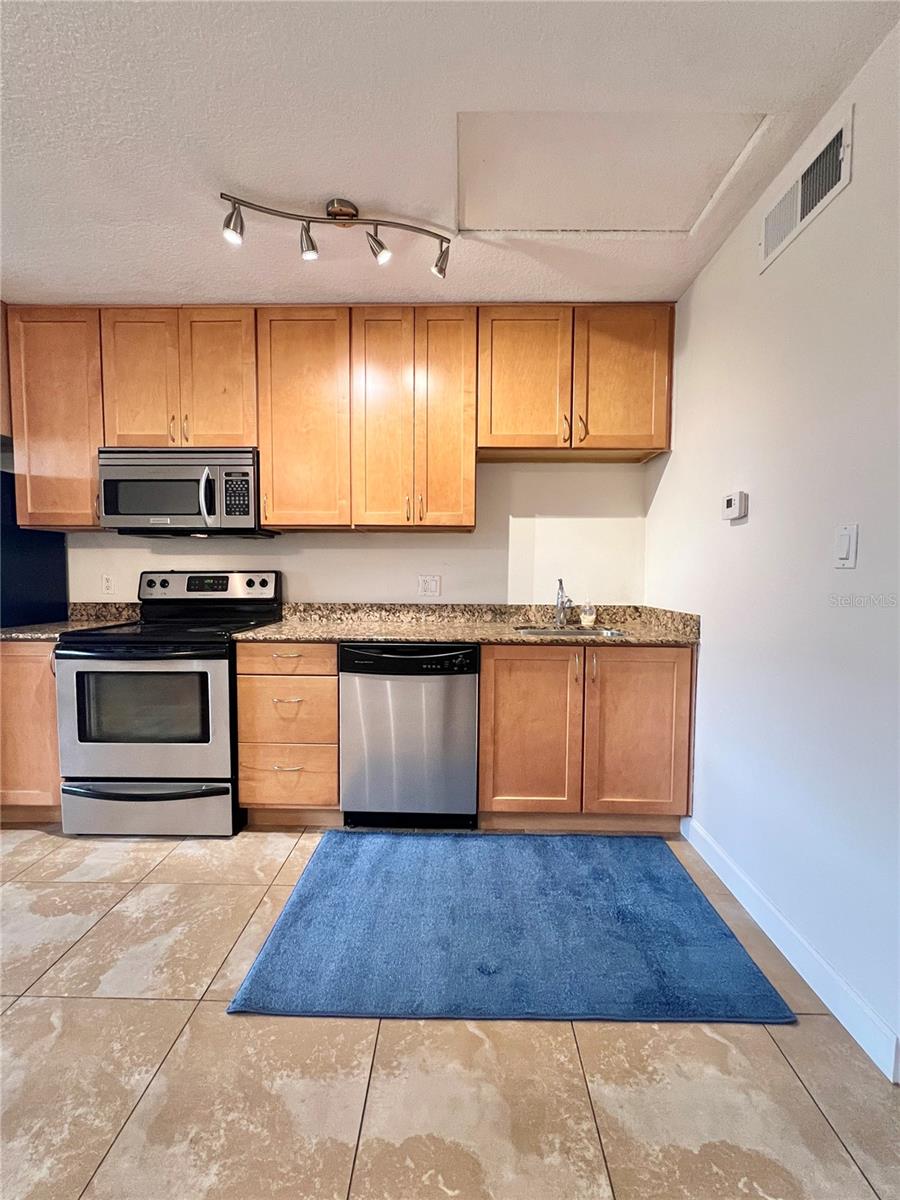 The kitchen features granite countertops and stainless steel appliances.