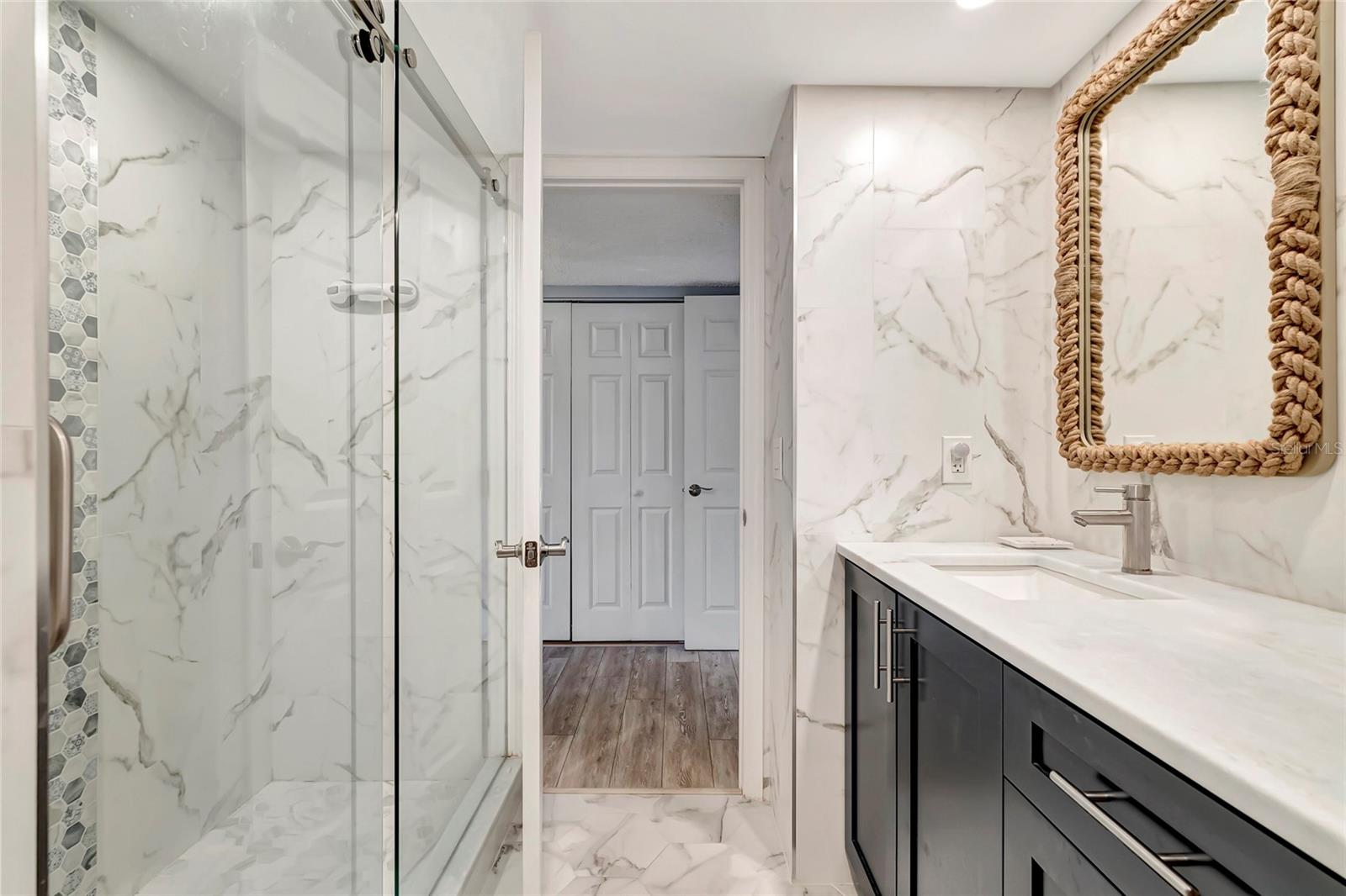 Featuring a spacious shower, sleek sink, and ample cabinets, this space combines practicality with style for your daily routine.