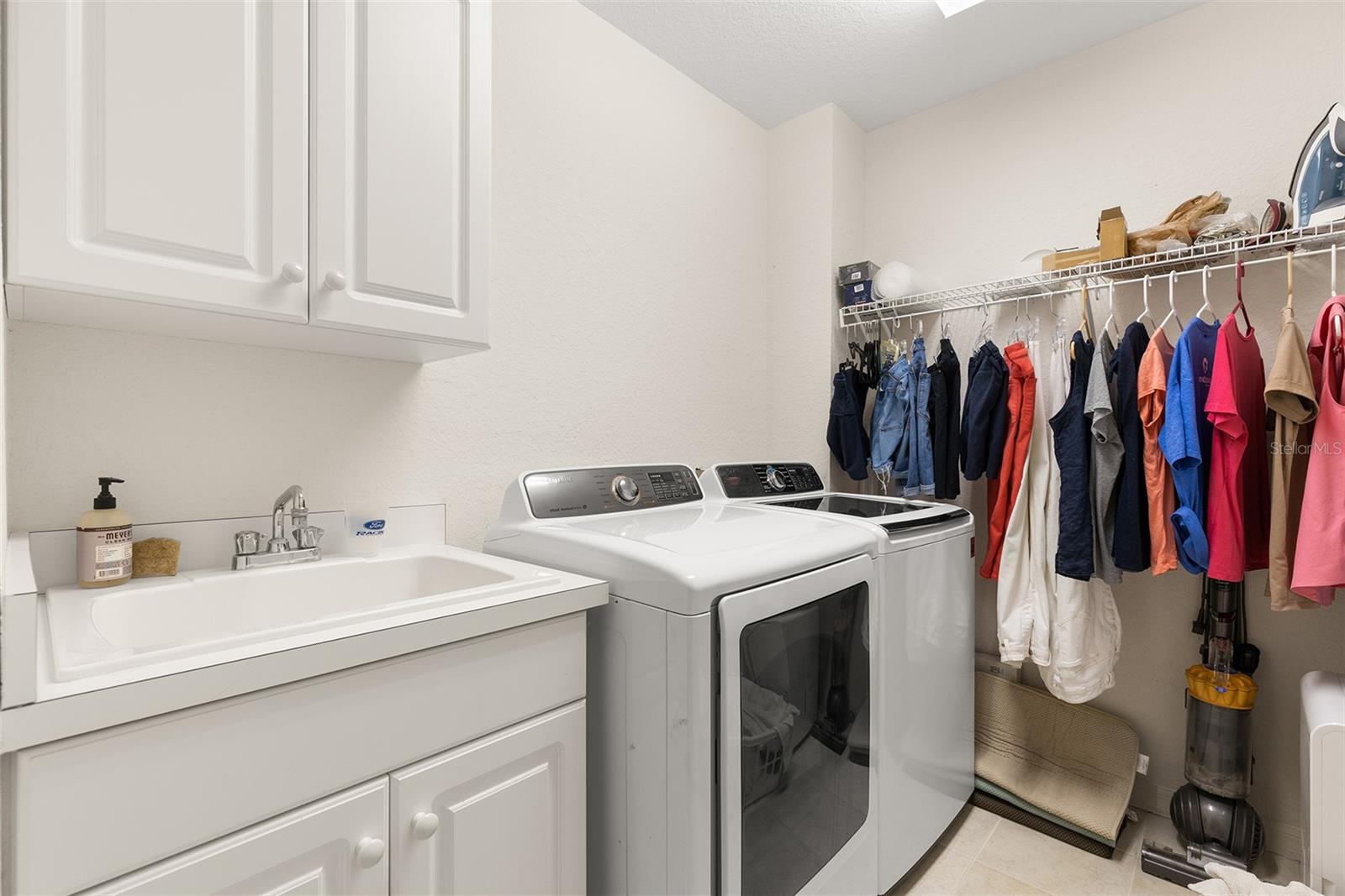 Spacious laundry room with sink and storage