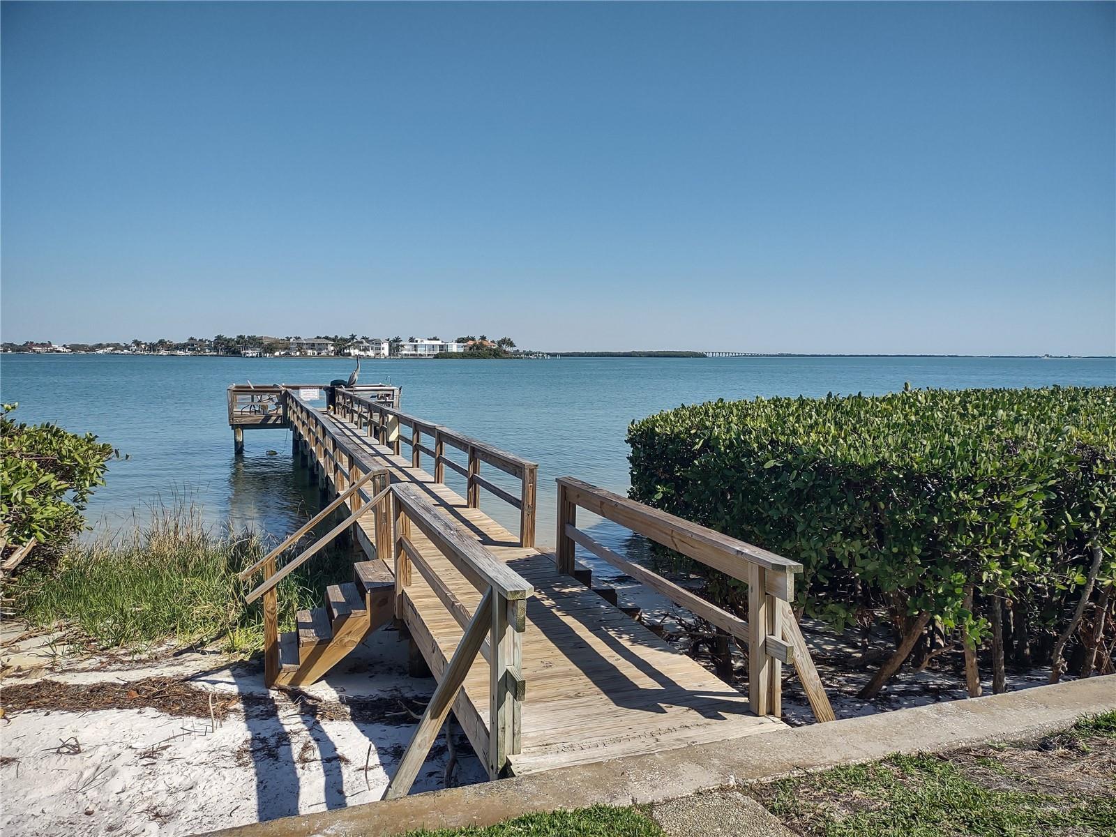 Fishing pier on shoreline by swimming pool area