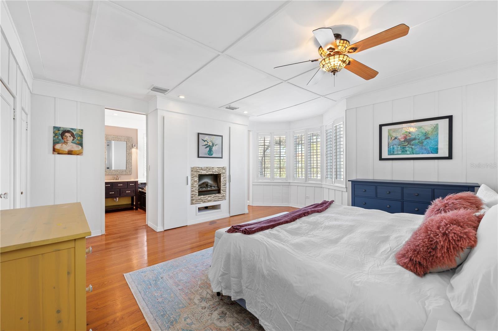 Spacious Master Bedroom with gorgeous detailed woodwork and two-sided fireplace.
