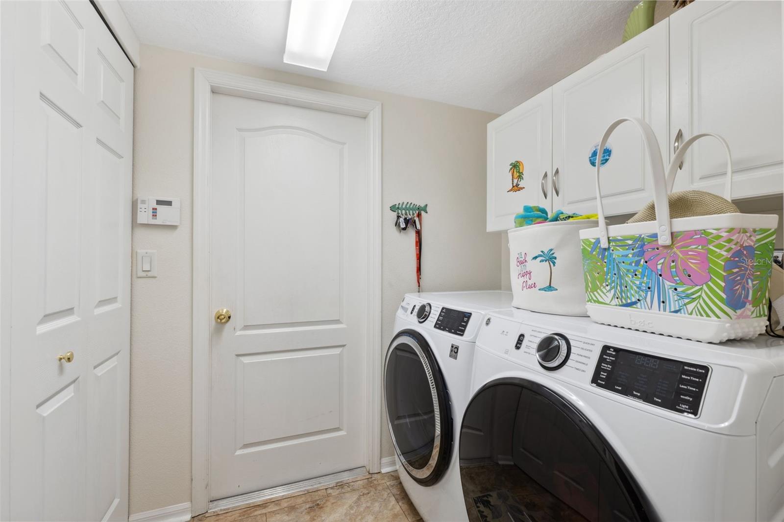 Laundry room with plenty of storage. Off kitchen, leading to garage.