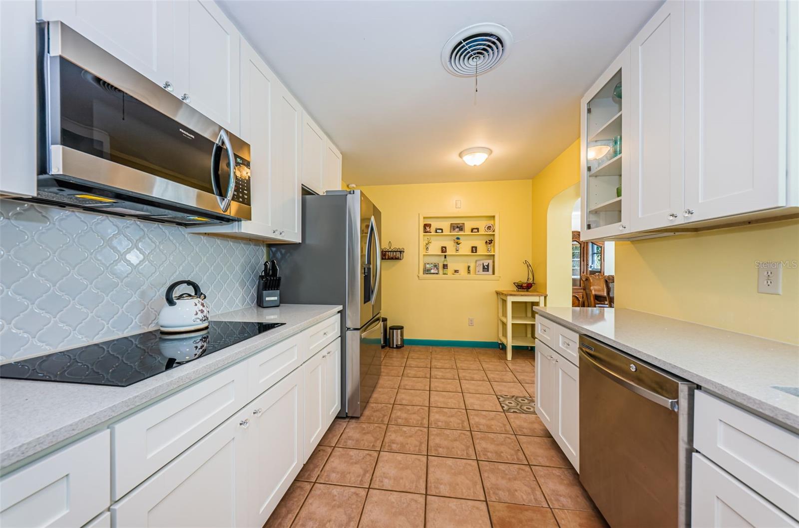 Fully remodeled kitchen with two walls of tall cabinetry and stainless steel appliances.