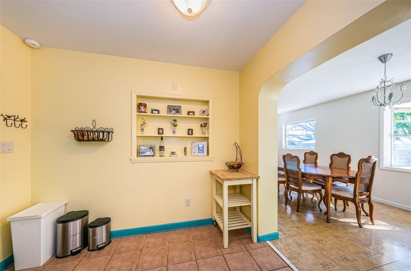 Kitchen has casual dining area and arched opening to formal dining room.