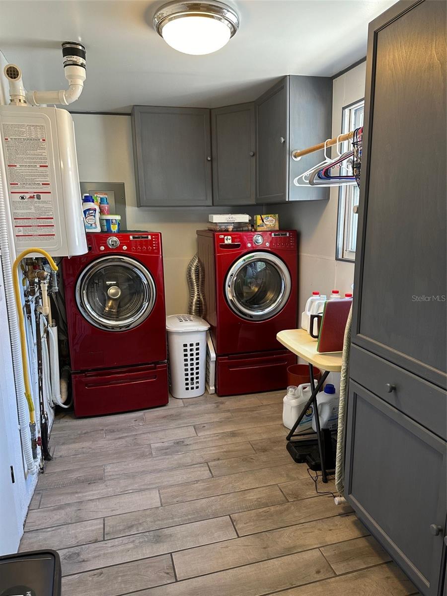 Just off the kitchen is the air conditioned laundry room with built in pantry. Washer and gas dryer convey. Note the tankless water heater on the left