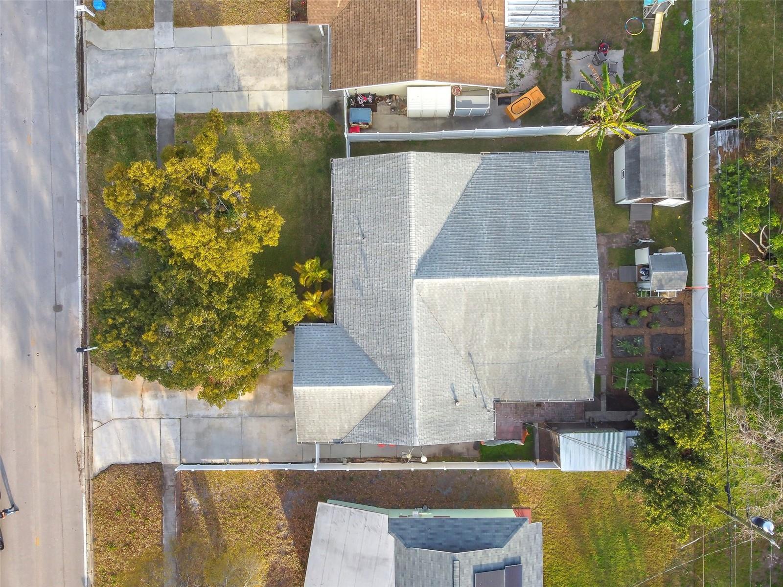 Drone view of property showing the backyard and sheds.