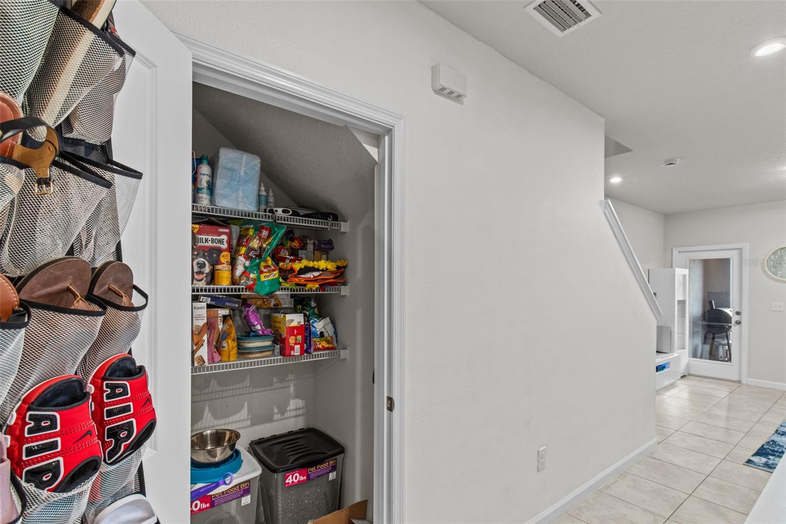 Under stair space designed as a pantry for plenty of storage.